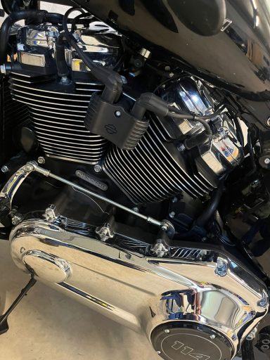 Detailansicht eines Motorradmotors mit glänzendem Chrom und schwarzen Kühlrippen.